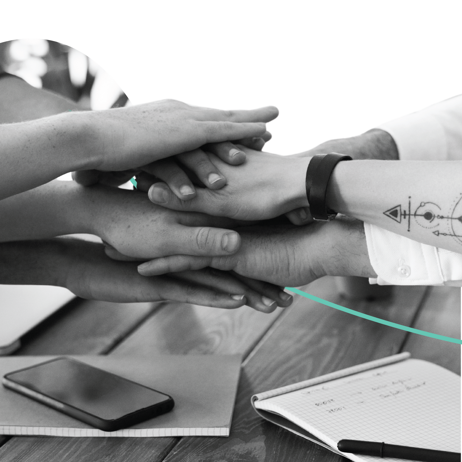 team at desk with hands together