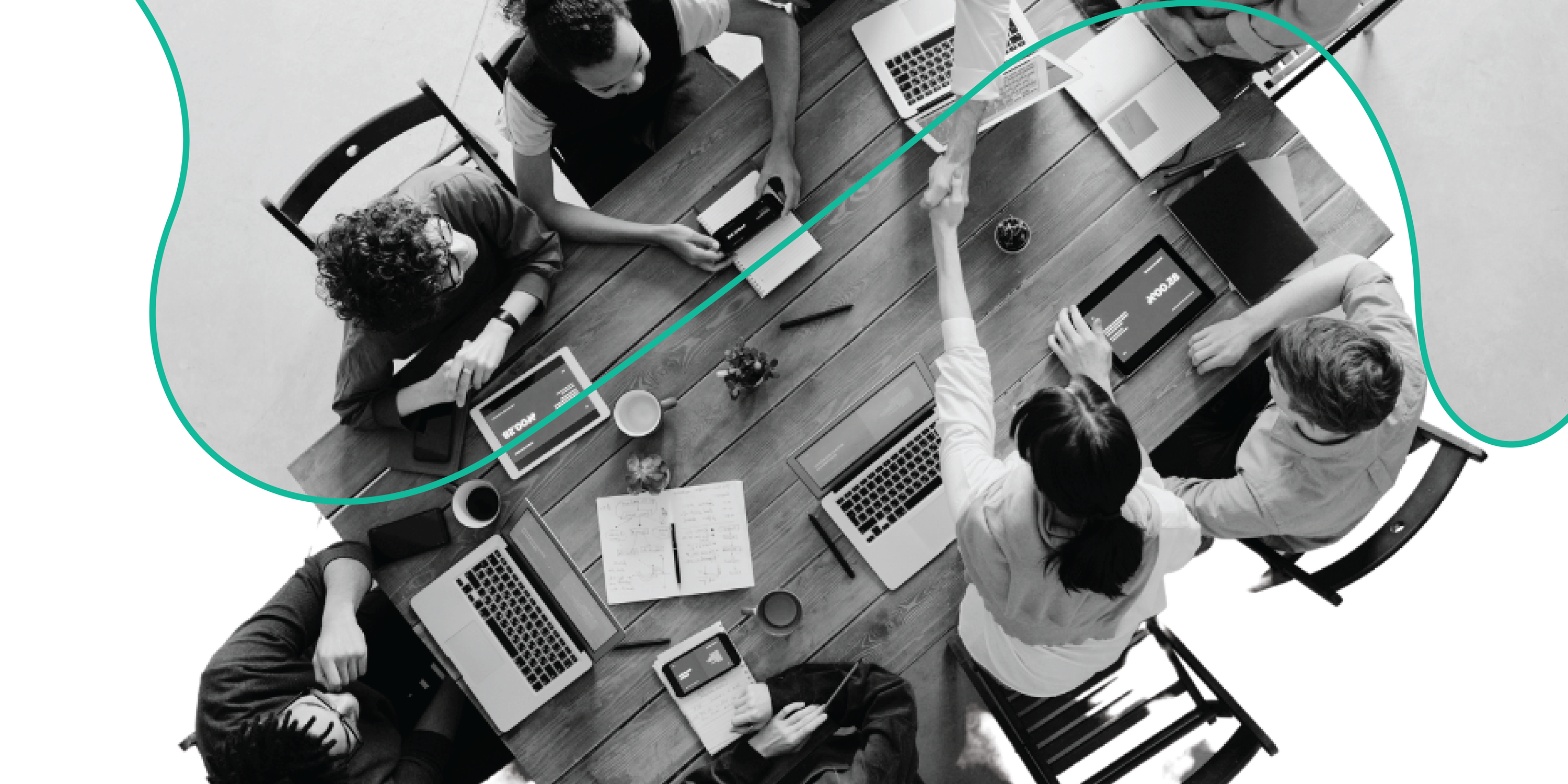 overhead view of group of people working at a desk in black & white