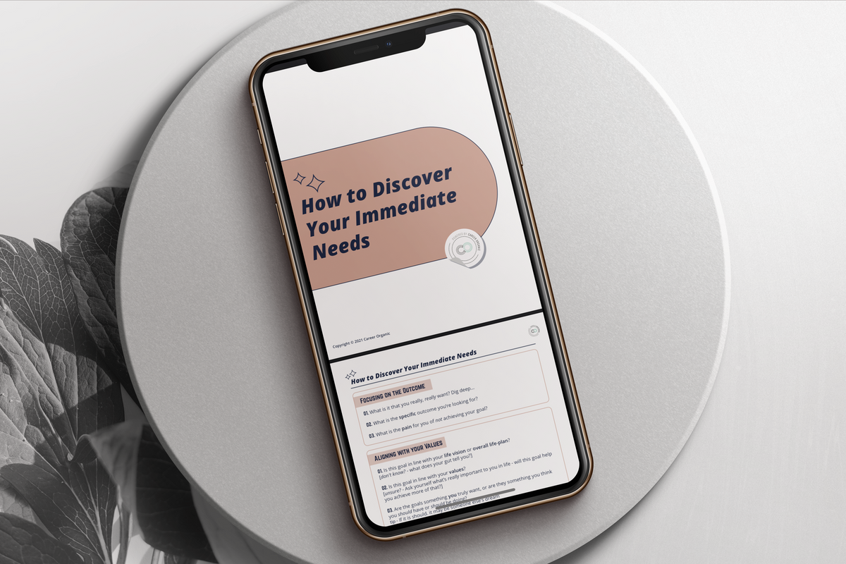 iphone on circular stone with a natural background, the screen displaying a free guide called how to discover your immediate needs