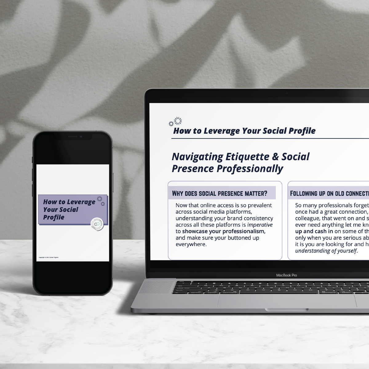 laptop with iphone on a marble table with plant shadows in the background, their screens displaying a free guide called how to leverage your social pofile