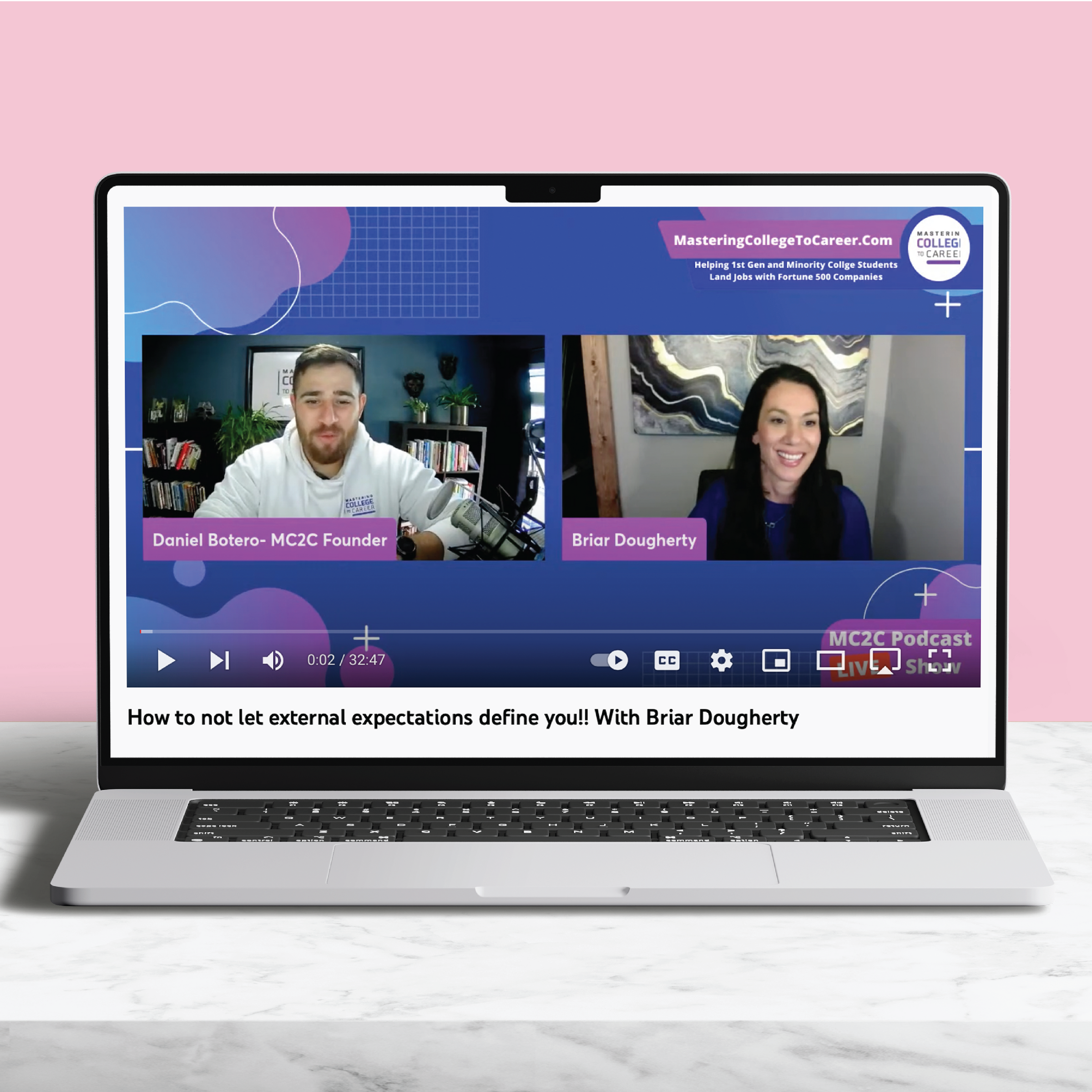 laptop displaying a virtual webinar with a man and a women on a pink background with marble table